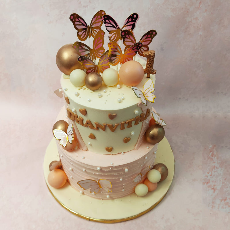 Furthermore, this butterfly birthday cake for girls comes frosted in decadent, baby pink buttercream, embellished with white pearls, gold hearts and gold butterflies all over.