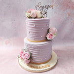 The choice of mauve as the primary colour for this two tier floral engagement cake with flowers holds deep symbolism within wedding traditions. 