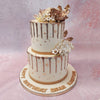 This stunning creation features a two tier golden drip cake, adorned with a touch of opulence through edible gold leaves delicately placed on the white bases.