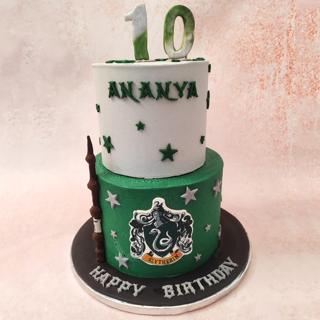 Featuring the Slytherin logo on the bottom tier and a greyish blue top tier, this two tier Slytherin cake captures the colour palette of this house and even showcases a life-like wizard's wand on the side.