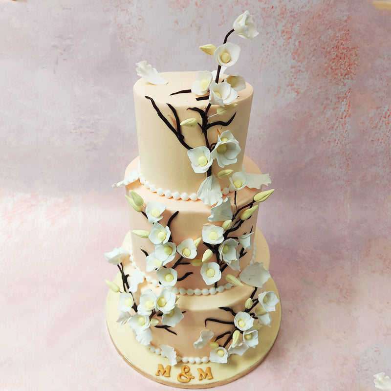 But what truly captivates the eye are the intricate white flowers, meticulously crafted in three-dimensional detail, cascading down the 3 Tier Pink Floral Cake design on graceful vines. 