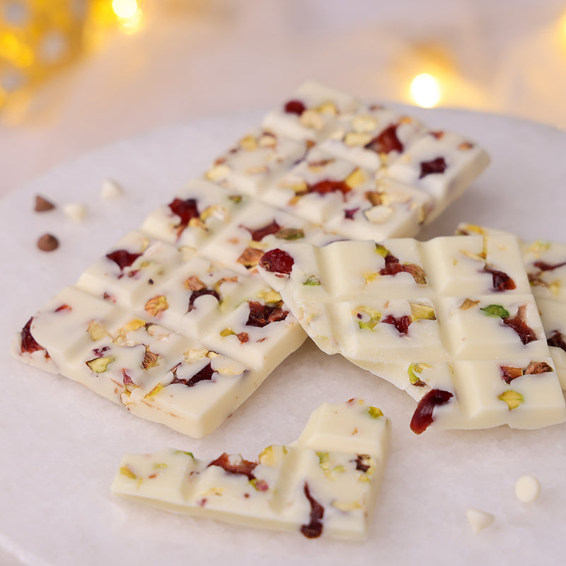 White Diwali chocolate bar topped with red cranberries and green pistachios