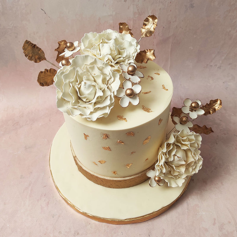 Immerse yourself in the allure of symbolism on this White and Gold Wedding Cake as white sugar roses bloom, embodying purity and the promise of a love that blossoms endlessly. 