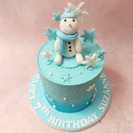 This Winter Theme Cake is set on a tall base that features a gentle ombre colour palette. 