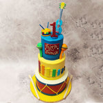 At the base of this, 3 Tier Musical Cake a robust drum sets the rhythm, a fondant masterpiece in chocolate that beats like the heart of a classic rock anthem. 