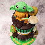 But that's not all! The chocolate drip frosting cascading down the sides of this two tier Yoda cake with macarons adds an element of excitement and adventure. It's like witnessing a lightsaber duel between Yoda and Darth Vader, with each drip representing a clash of power.