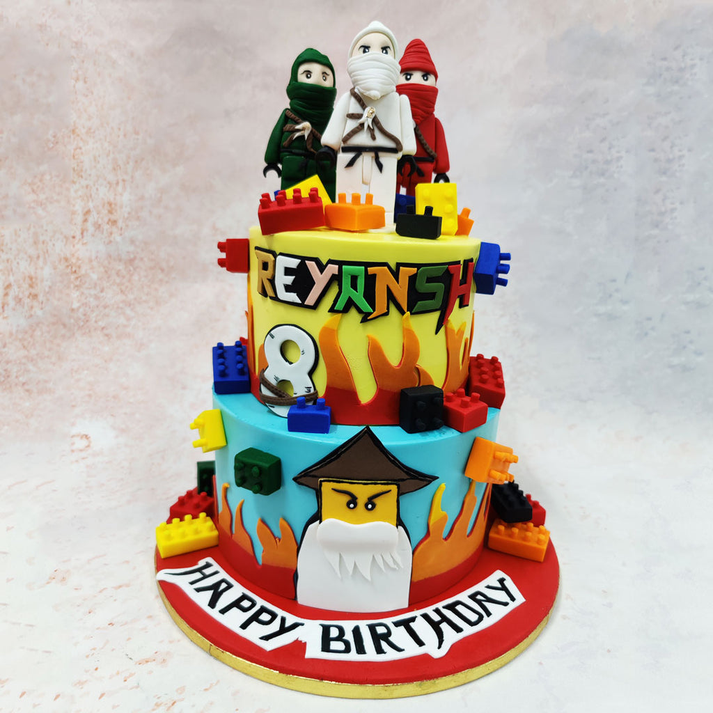 At the top of this Zane Ninjago Cake, detailed edible figurines of brave ninjas stand ready for action, their intricate robes and weapons adding a touch of realism. 