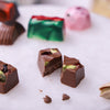 Milk Chocolate Christmas Chocolate sliced open, showing pistachio, cranberry, and soft milk chocolate filling.