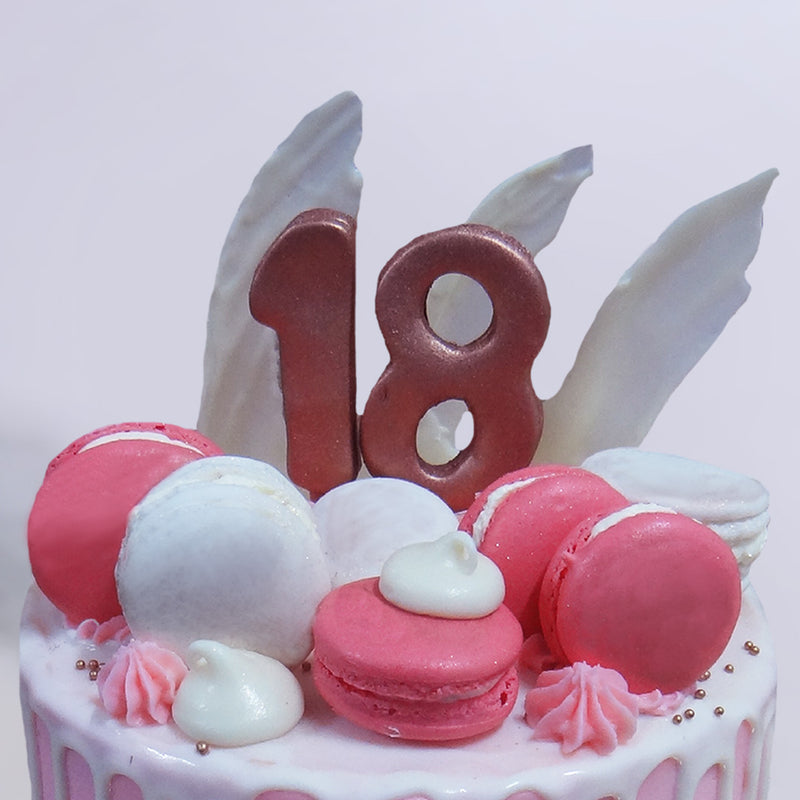 This 18th birthday cake for boys/girls looks like a delicious strawberry milkshake, doesn't it? The vibrant pink colour of the macaroons cake base combined with the milky white drip pattern of the frosting on top is intended to give the fresh feeling of sipping on a shake in summer