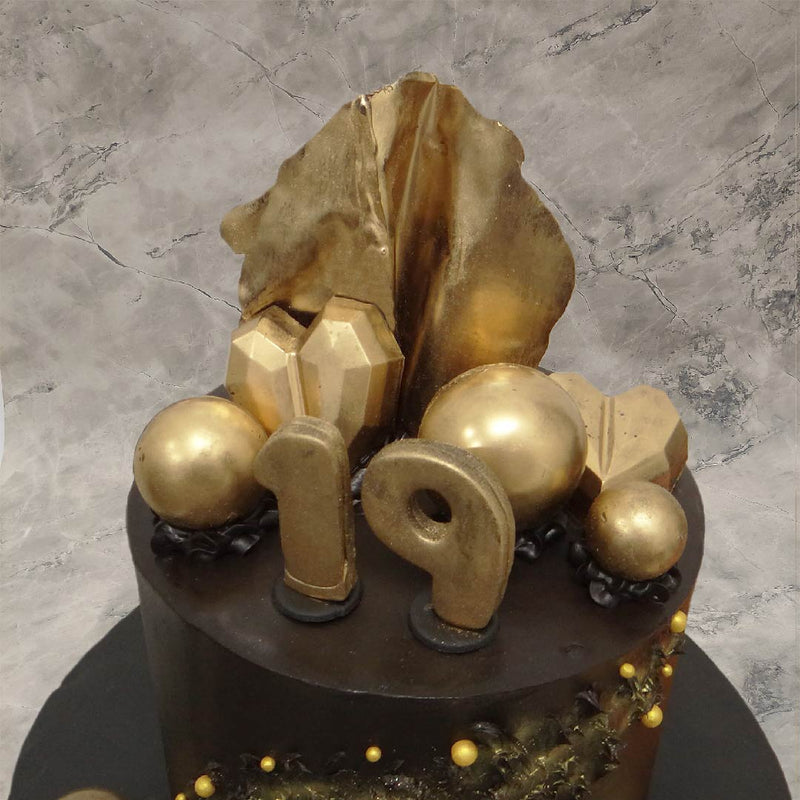 Zoomed view of 19th birthday cake which is actually a black and gold theme cake where all the elements of this cake are clearly visible