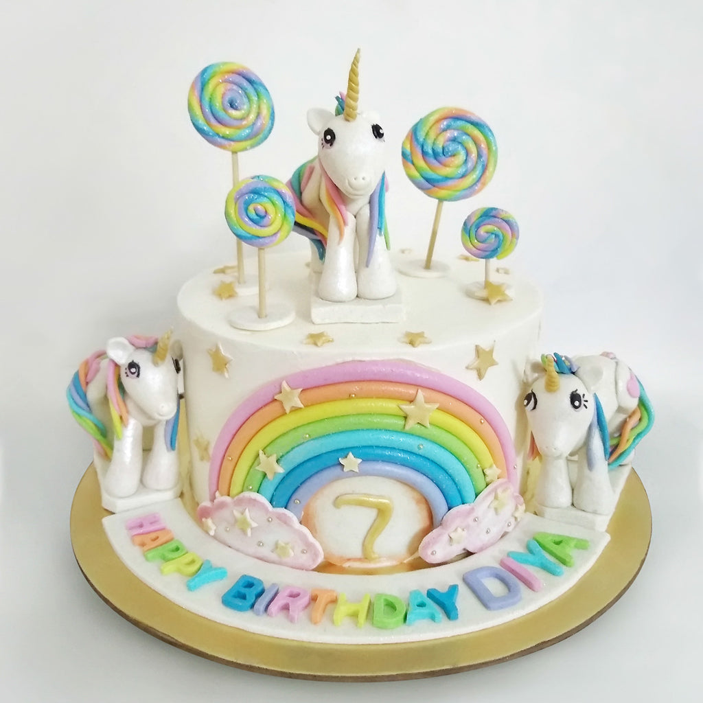 Unicorn cake with little ponies on top of the rainbow unicorn cake 