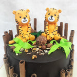 Chocolate wafers engulf the entire circumference of this tiger birthday cake for kids like bamboo in a reserve.