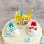 A cute 3D baby pram is kept on top of this cake with little baby boots of pink and blue colour to keep the surprise of a baby boy or baby girl cake
