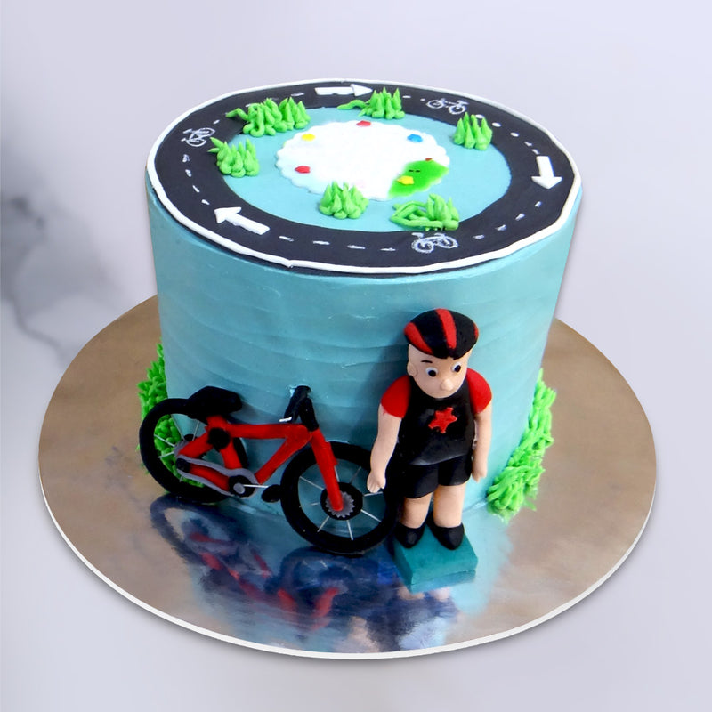 Bicycle theme cake with cycle track on top of the cake and a cyclist on side of this cake. This is a perfect cake for dads 50th birthday