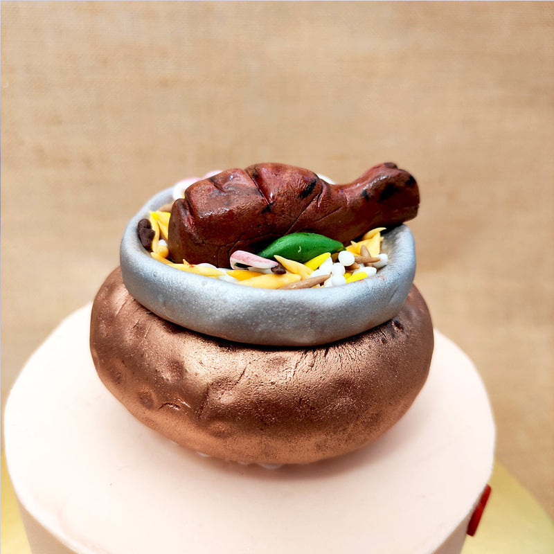 Zoomed view of biryani theme cake which showcases a fondant made juicy grilled chicken leg piece which every biryani lover is looking for in his pot of biryani. This biryani cake will surely be a best surprise cake for a biryani lover