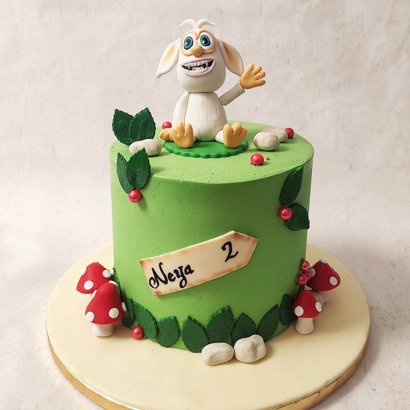 This Booba birthday cake for kids features a rather simplistic yet artistic design, with a grassy green base, engulfed by vibrant mushrooms, pebbles and leaves that brings the world of the show to life. 