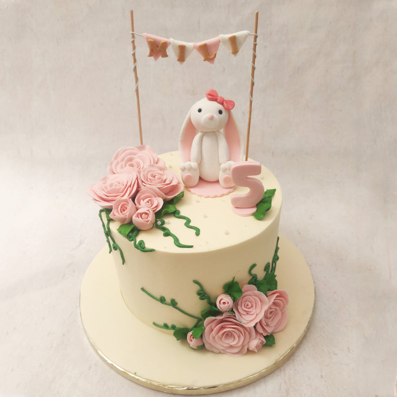 Under this arbor sits a cute, little bunny with a pink bow on her head and ears that touch the ground. The stuffed-toy resemblance of this bunny, further adds to the child-like playfulness of this animal theme cake