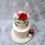 The bottom base of this bunny cake for kids represents the body and the top is created like the head where the whiskers and eyes have been sketched on in a delicious, black buttercream.