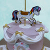 White cloth has been recreated to adorn the sides of the carousel birthday cake base, pinned down with white roses and golden bows bearing a resemblance to the tables at a wedding reception.