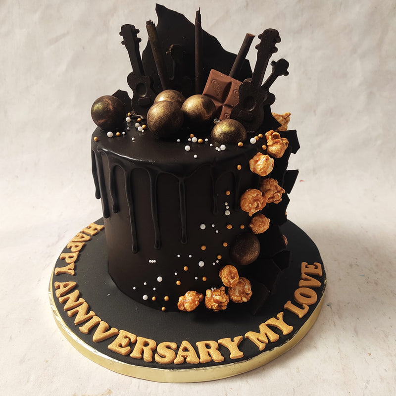  Featuring sword-like embellishments of chocolate shards and ukuleles on top, the dark aesthetic of this chocolate drip cake is complemented by the gold baubles and caramel popcorn trickling down the side in line with the chocolate drip pattern.