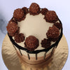 Top view of chocolate drip cake with ferrero rochers on top of the cake settling down on a chocolate ganache piping. This ferrero rocher chocolate drip cake is an ultimate cake for any chocolate lover