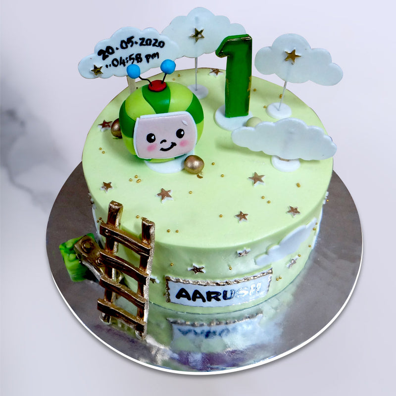 top view of cocomelon theme cake which shows all the different elements on top of the cake and golden ladder on side of the this first birthday cake