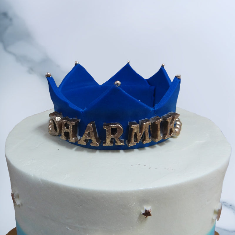 Zoomed view of crown birthday cake to highlight blue crown sitting on top if then cake with name engraved on it. This is surely the best birthday cake for your little prince