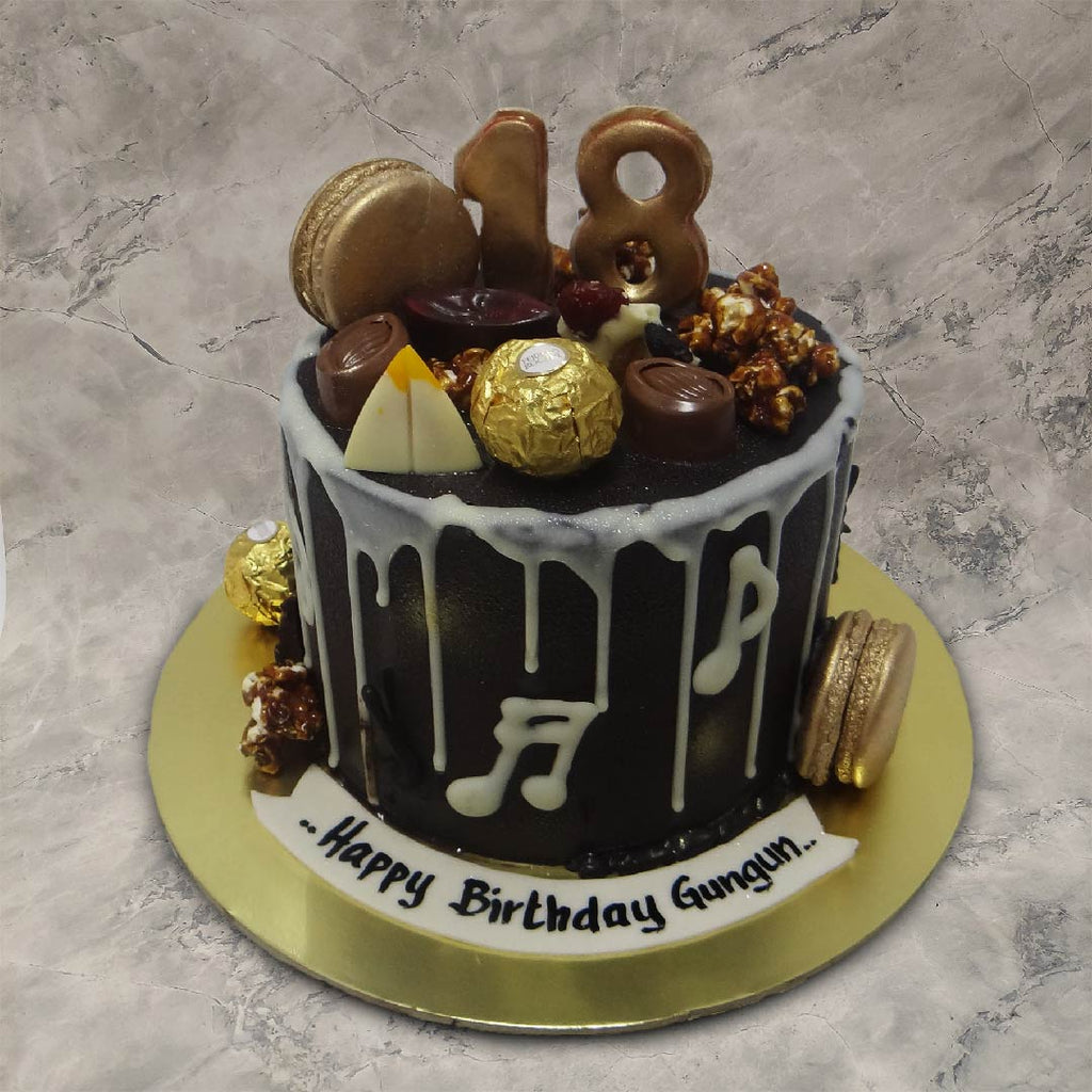 Fancy chocolate birthday cake with real pralines and truffles on top with that golden macaroons and caramalised popcorns on sides to bring all the joy and fun to this 18th birthday cake