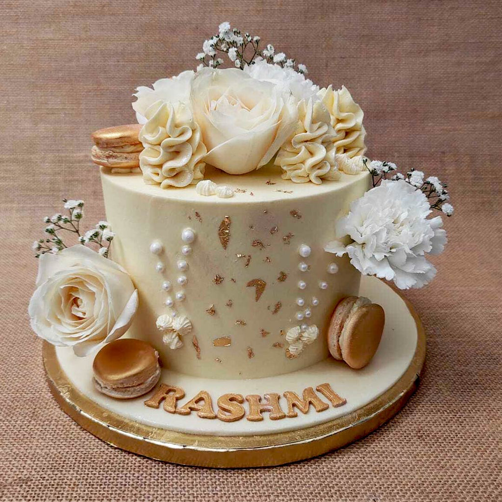 This White floral cake comes laden with beautiful and real white flowers and baby's breath. The entire design has been artistically crafted like an edible vase that could form the centerpiece at any grand occasion. With a luxe look and artistic aesthetic, for this floral cake design, elegance was the name of the game.