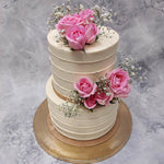 This two tiered floral wedding cake is the ultimate symbol of love…a real flower cake featuring pink roses and baby breathes, this would also serve well as an anniversary cake for him/her 