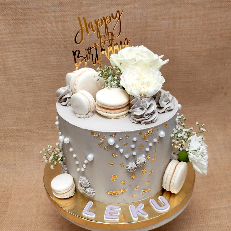 Floral wifes birthday cake is a special cake to celebrate the bond of love between a wife and husband. This florist cake has lot of elements on it like macaroons, edible flowers, pearls and edible gold leaf