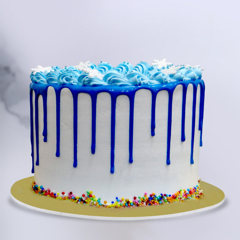 Side view of frozen theme cake shows the blue icing drips and fumfetti on the bottom of the cake. This princess birthday cake tastes as beautifull as it looks 