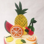 Both tiers of this fruit theme birthday cake for her / him feature an artistically minimalistic design with colourful 2D fruit figurines all over.