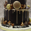The base of this golden drip 50th anniversary cake is filled with macaroons, caramalised popcorns and chocolate rochers