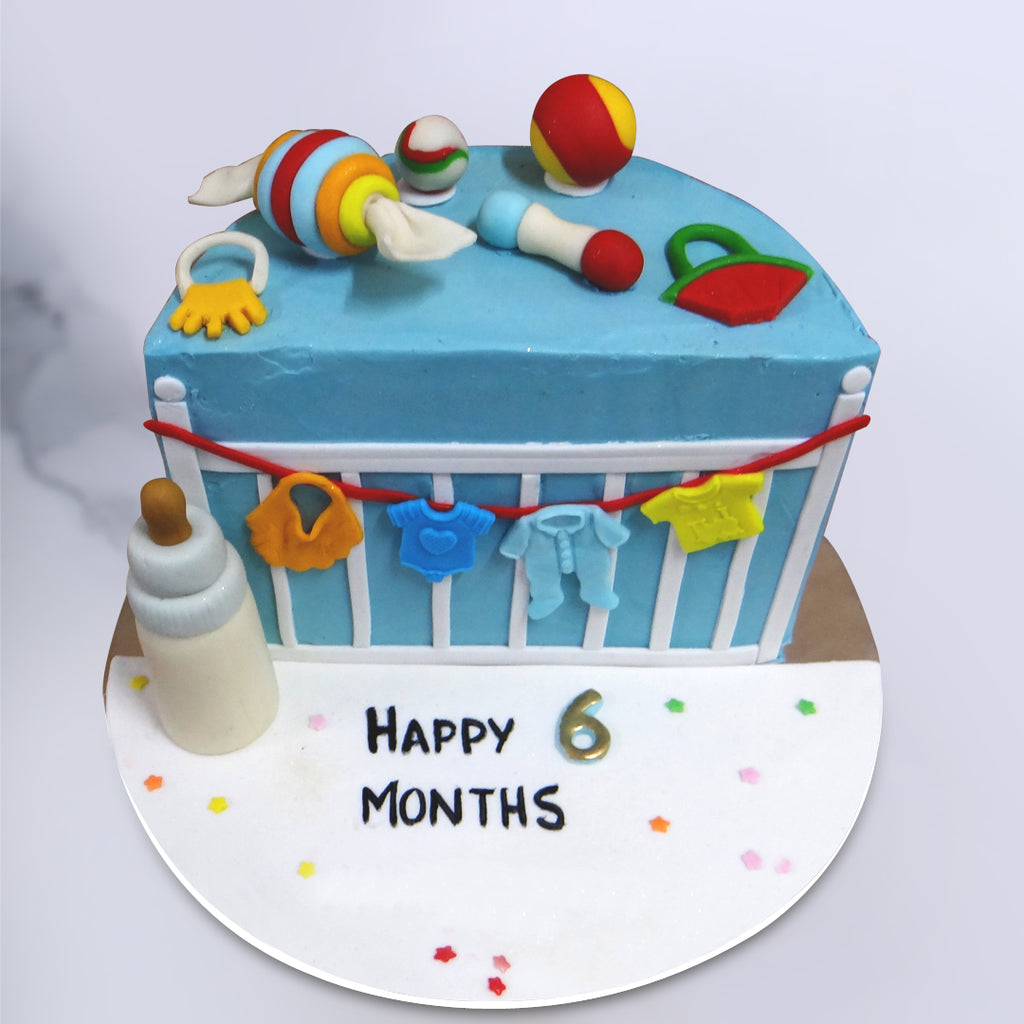 This toy theme cake comes garnished with an assortment of edible baby toys from rattles to baby teethers. An edible feeding bottle can also be found at the base of this toy cake that is completely life-like and utterly delicious, making it a great choice for a “halfway to one” cake