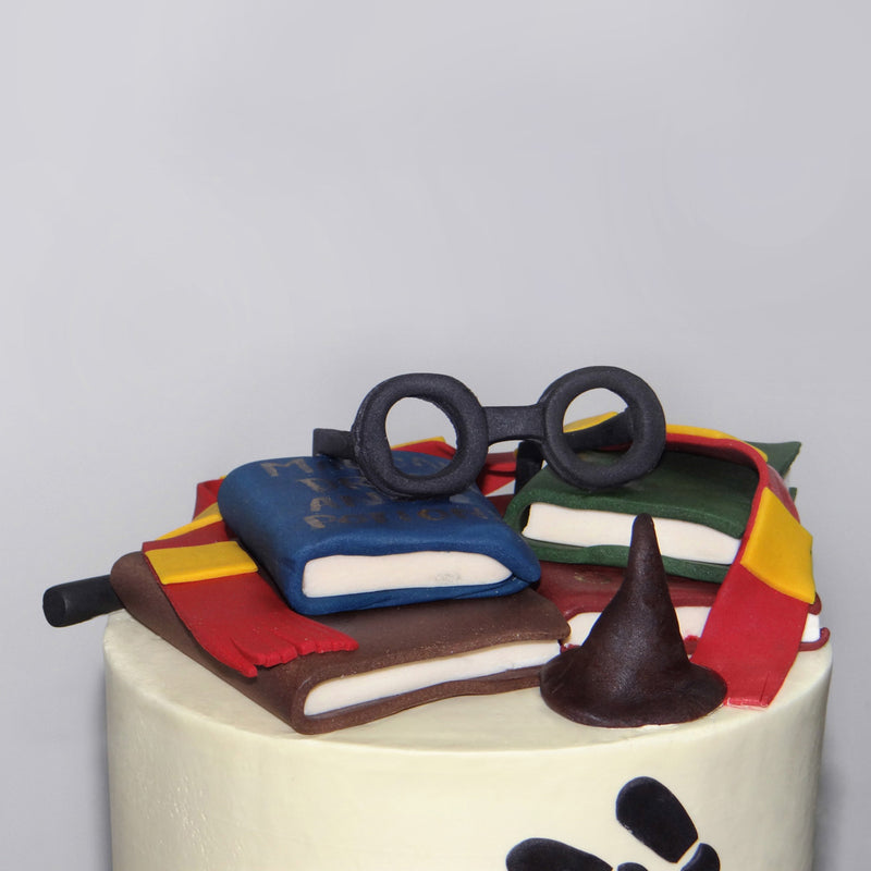 Harry potter themed cake with Books and spectacles on top of the cake make it look so attractive for a birthday themed cake 