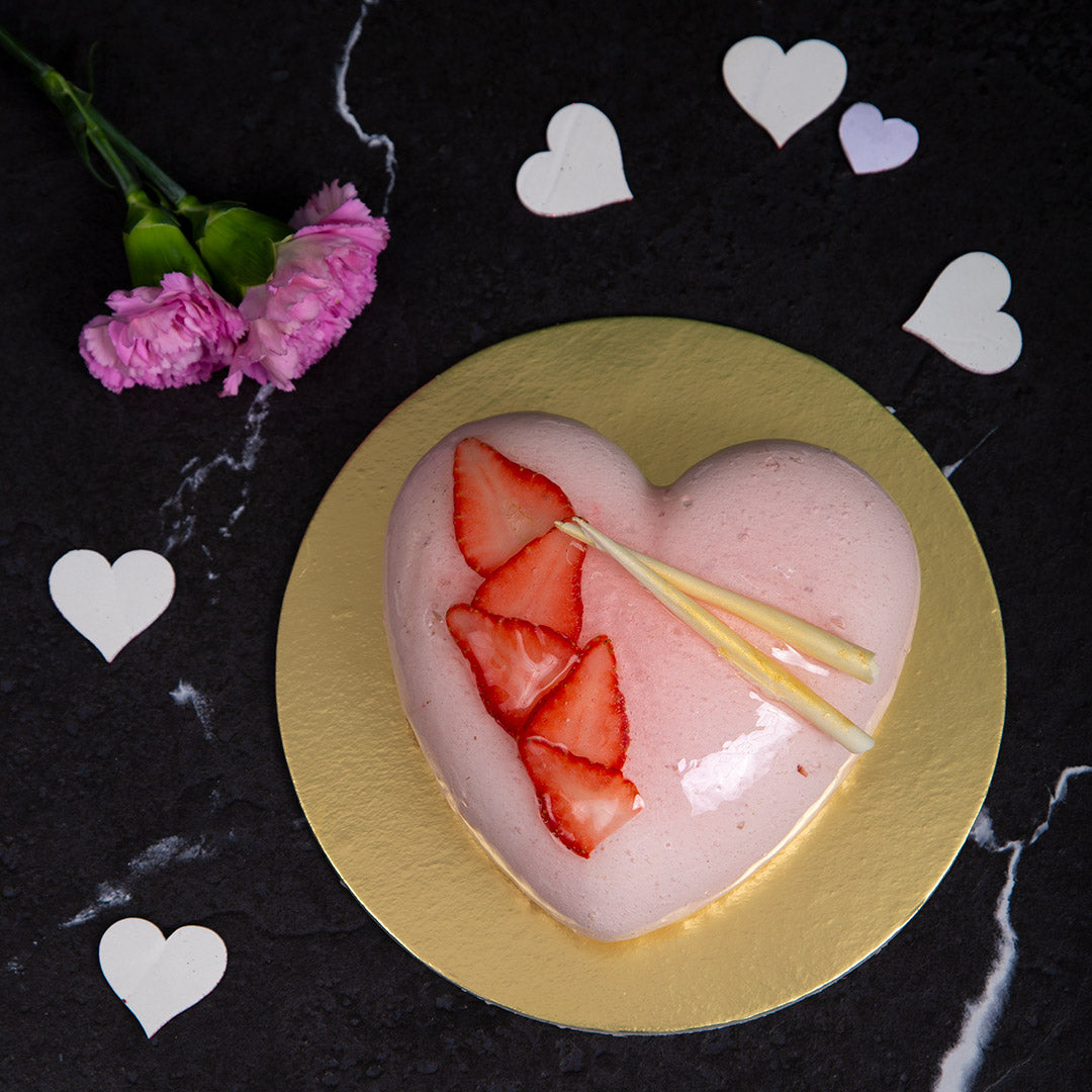 Mousse cake with pink mirror glaze, decorated with heart, macarons, and  strawberry Stock Photo - Alamy