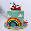 Helicopter cake with a mini colourful helicopter on top and all the clouds, rainbow and tall buildings surrounding these cute helicopter cake