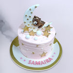 Top view of this Hug the moon cake where the pink cake for her holds a crescent moon and golden stars surrounding the moon. This is surely a best option for a baby shower cake or as a kids first birthday cake