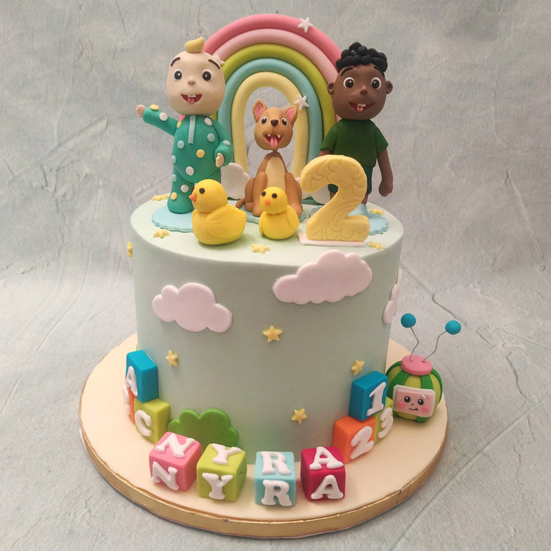  Miniature, edible figurines of Baby JJ, Bingo The Dog and Cody can be spotted on top of this Cocomelon Baby JJ cake and a star-studded rainbow can be seen behind them, presenting the promise of hope and magic.