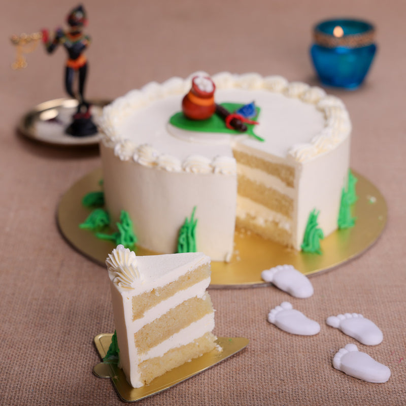Cut view of Krishna theme cake shows the purity of white forms the base of the little Krishna theme cake and this lord Janmashtami birthday cake is set amongst the green trees of the ‘Mathura forest. What better happy birthday Kanha ji cake than one that is topped with a pot of butter oozing out of it?