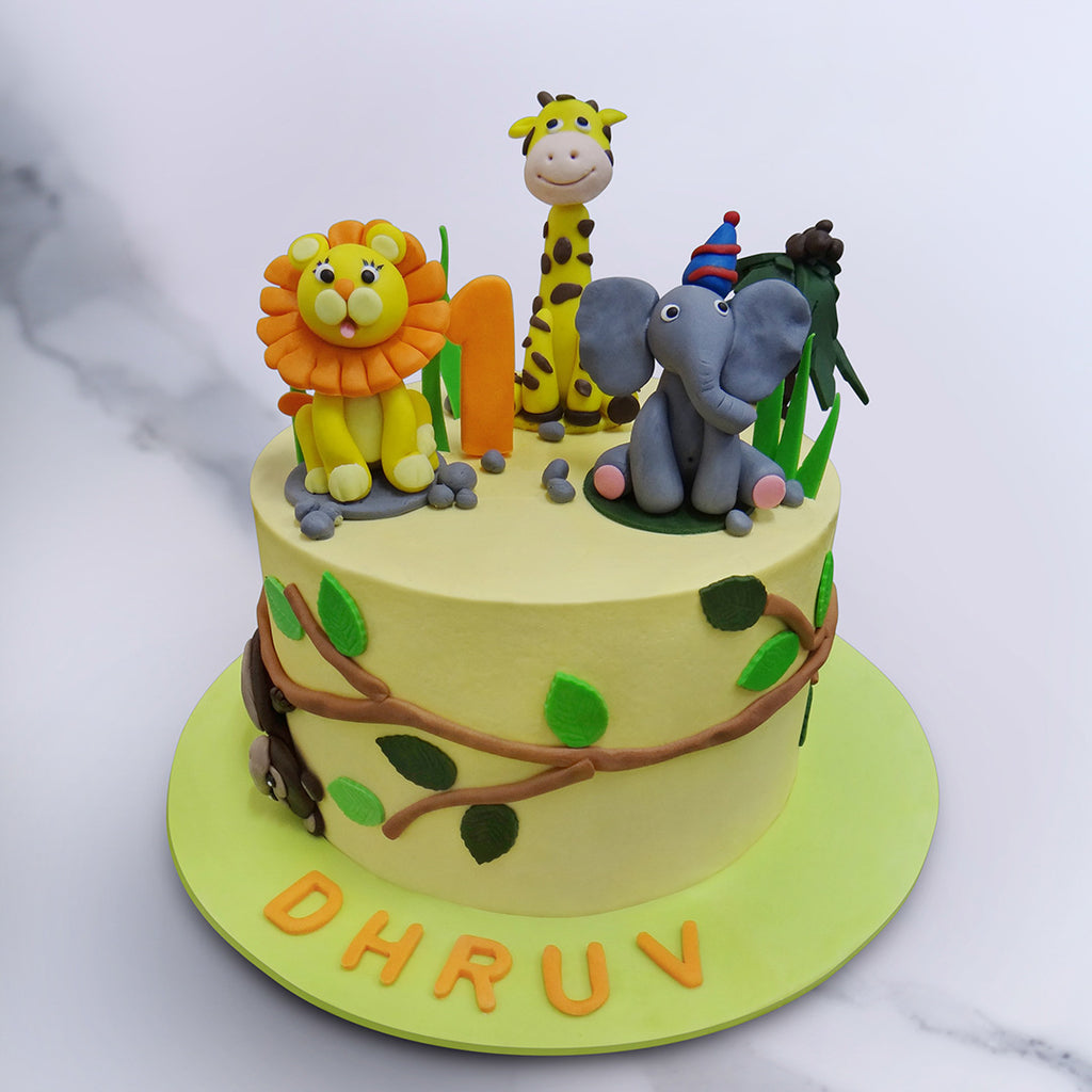 Jungle theme cake is filled with animals like Lion, Giraffe. Elephant and a monkey 