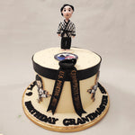 This Karate cake design features a simplistic, artistic and minimalistic white base with a black belt around the top which complements  the black Grand Master ribbon on the side.