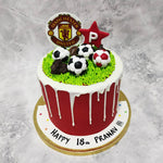 Front view of manchester united cake where you can see white chocolate drips running down the cake