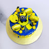 Top view of our Minions cake with small Minion on top of the cake and yellow tasty macaroons with fondant pineapple & banana which is adding more values to this Minion theme cake