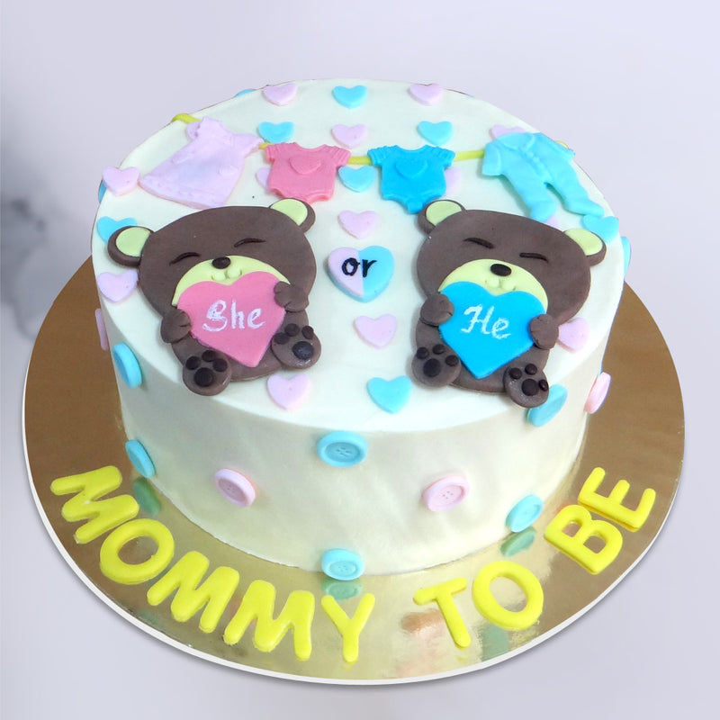 This mommy to be cake is special because there are 2 teddy bears on top of the cake holding a tag of "He" or "She" and with that there are baby clothes hanging on the top of the cake. This teddy bear baby shower cake is surely a great option to celebrate with the baby shower function