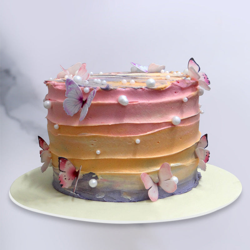 Beautiful Ombre cake with three shades of colour and edible butterflies all around the cake. This Colorful cake is as delicious as it looks 