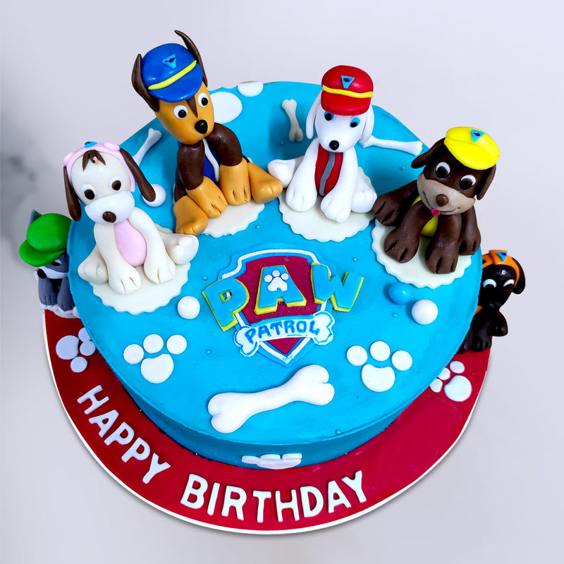 Top view of paw patrol cake or super hero birthday cake you can see all the characters sitting on top of the cake and a paw patrol logo places right in center of the cake