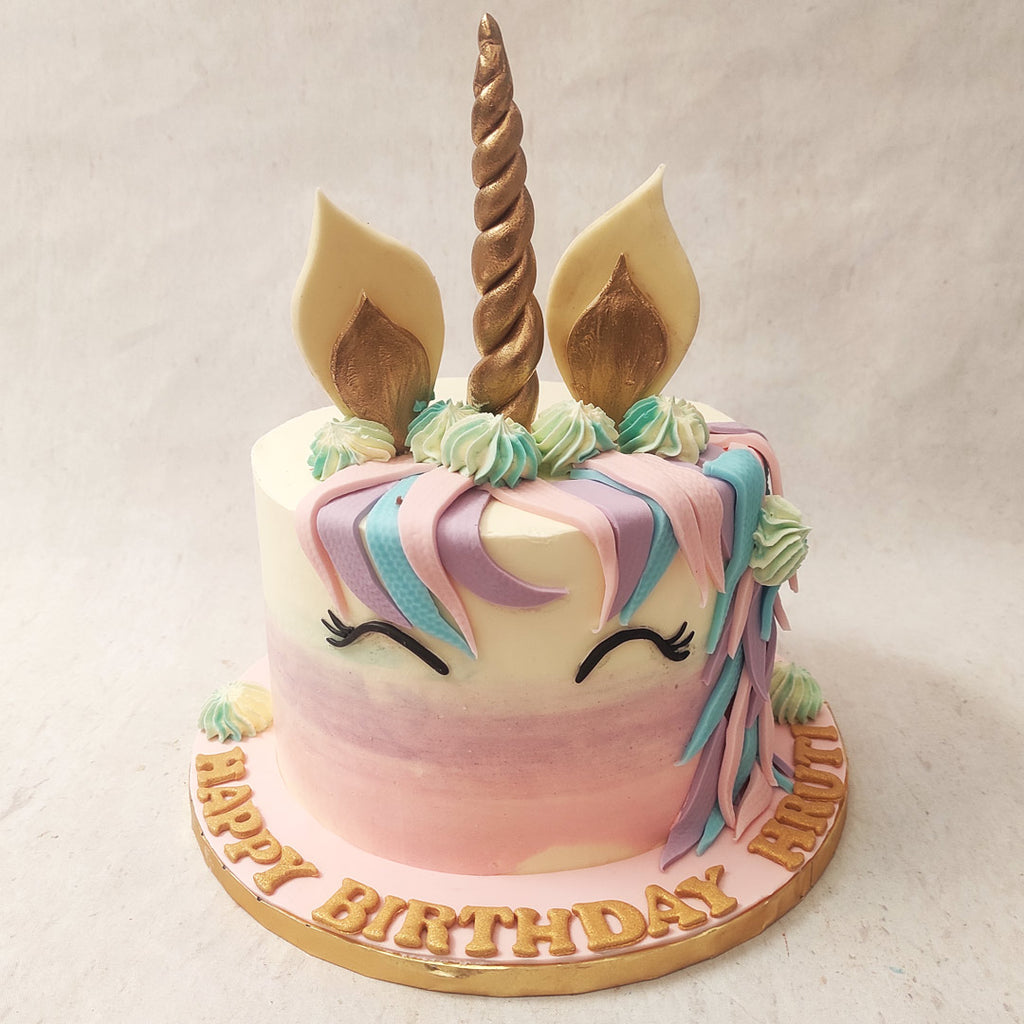 With a pink to white ombre used for the colour pattern of the base of this cute unicorn cake, a precious smile is alluded to through this unicorn's closed eyes