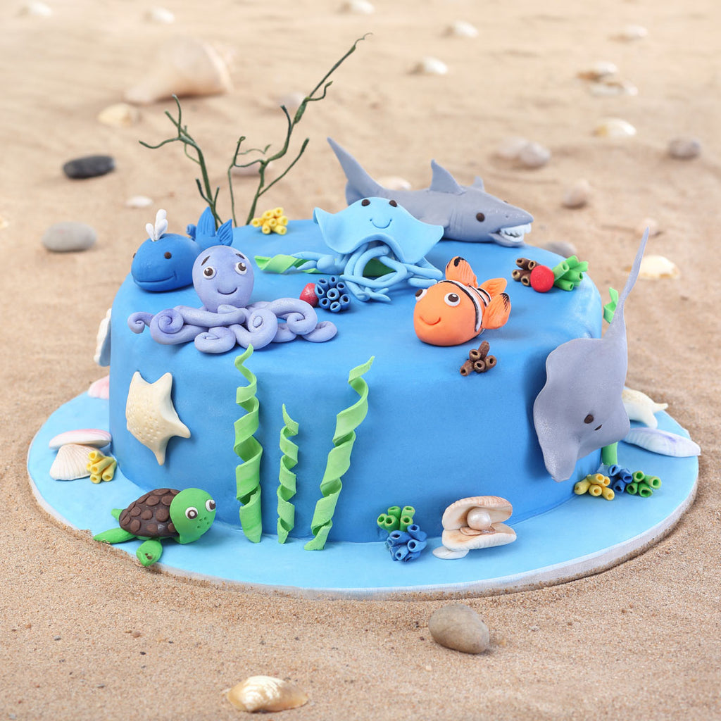 Sea Theme Cake Front View with all small cute fondant sea animals like octopus, sting ray, shark, whales, turles and a cute little clown fish. This sea theme cake is surely a kids birthday cake 